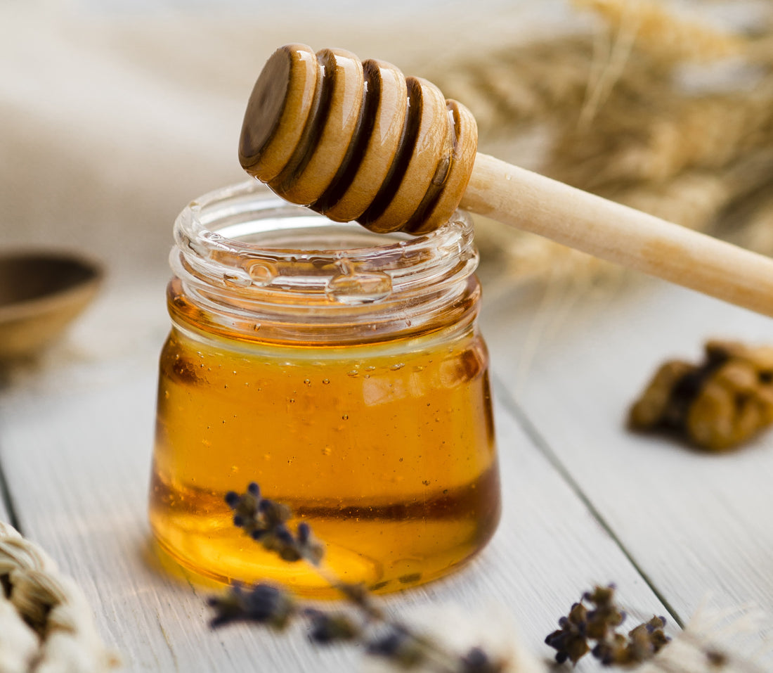 Kashmiri wildflower honey in a glass jar with a honey dripper